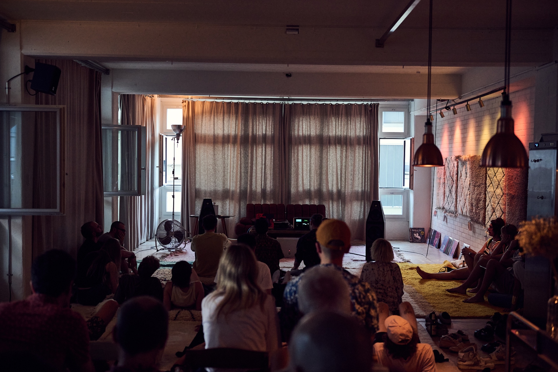 Publikum sitzt am Boden bei einer Listening Session